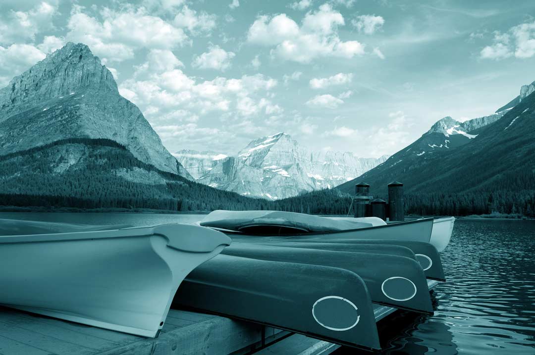 Canoes racked on a lake dock, teal duotone